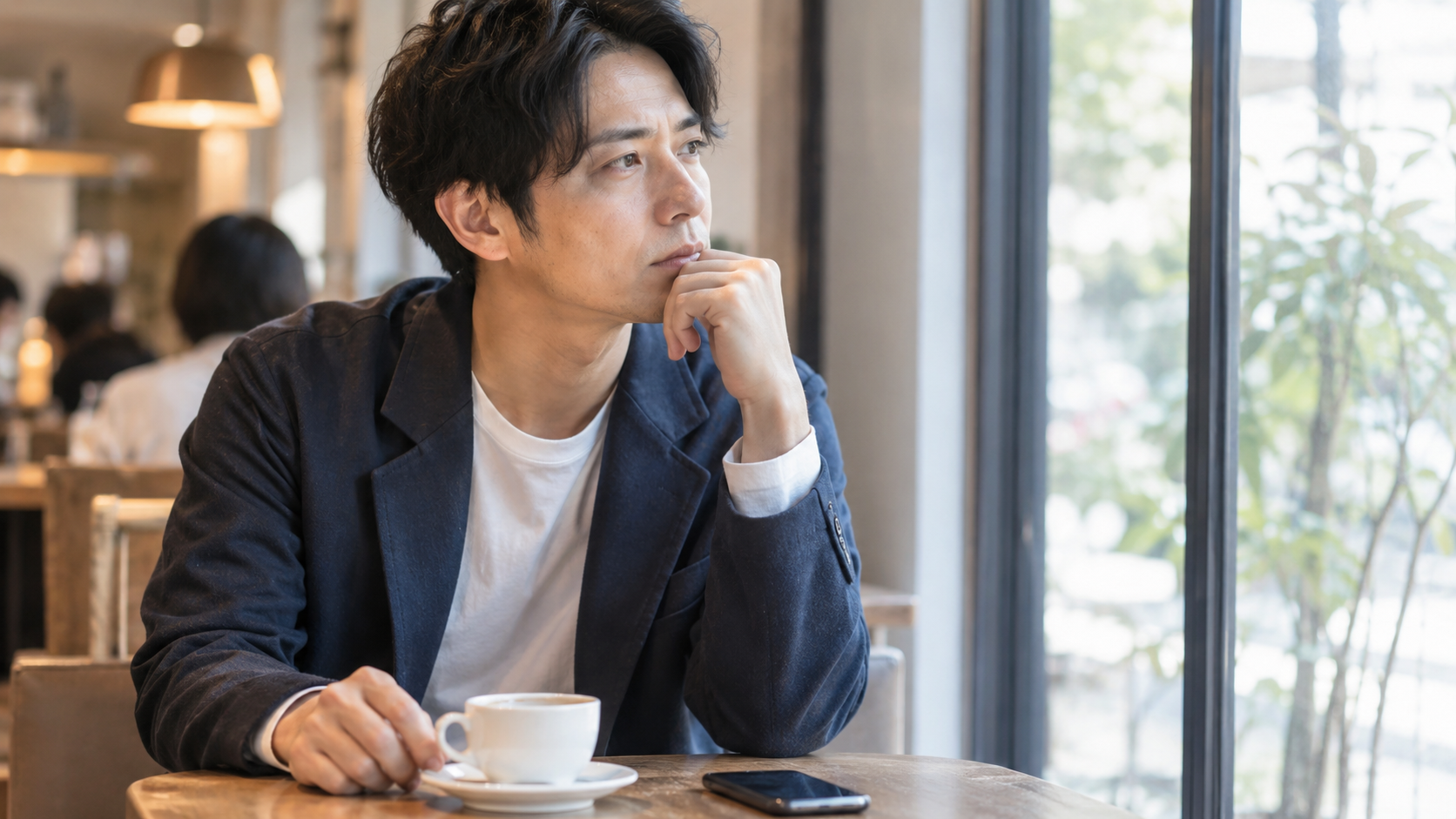カフェで女性との関係について考える男性